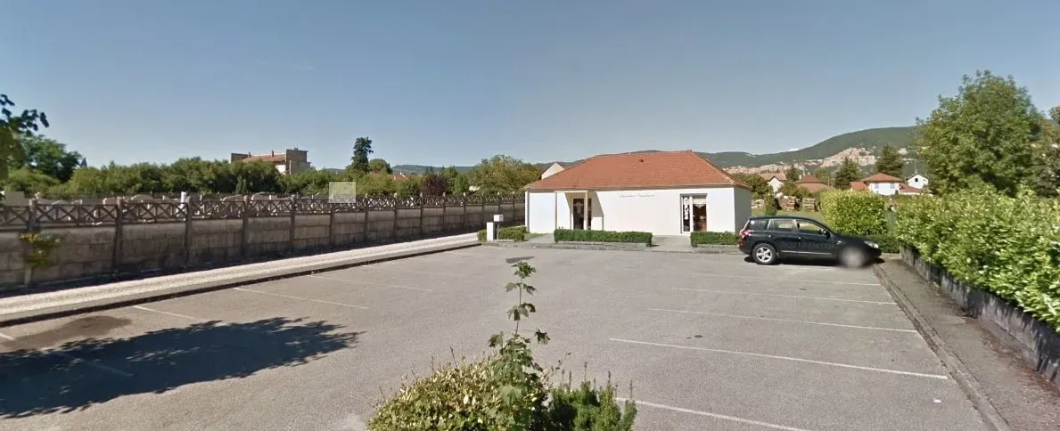Grand parking privé et extérieur d'une agence de pompes funèbres.